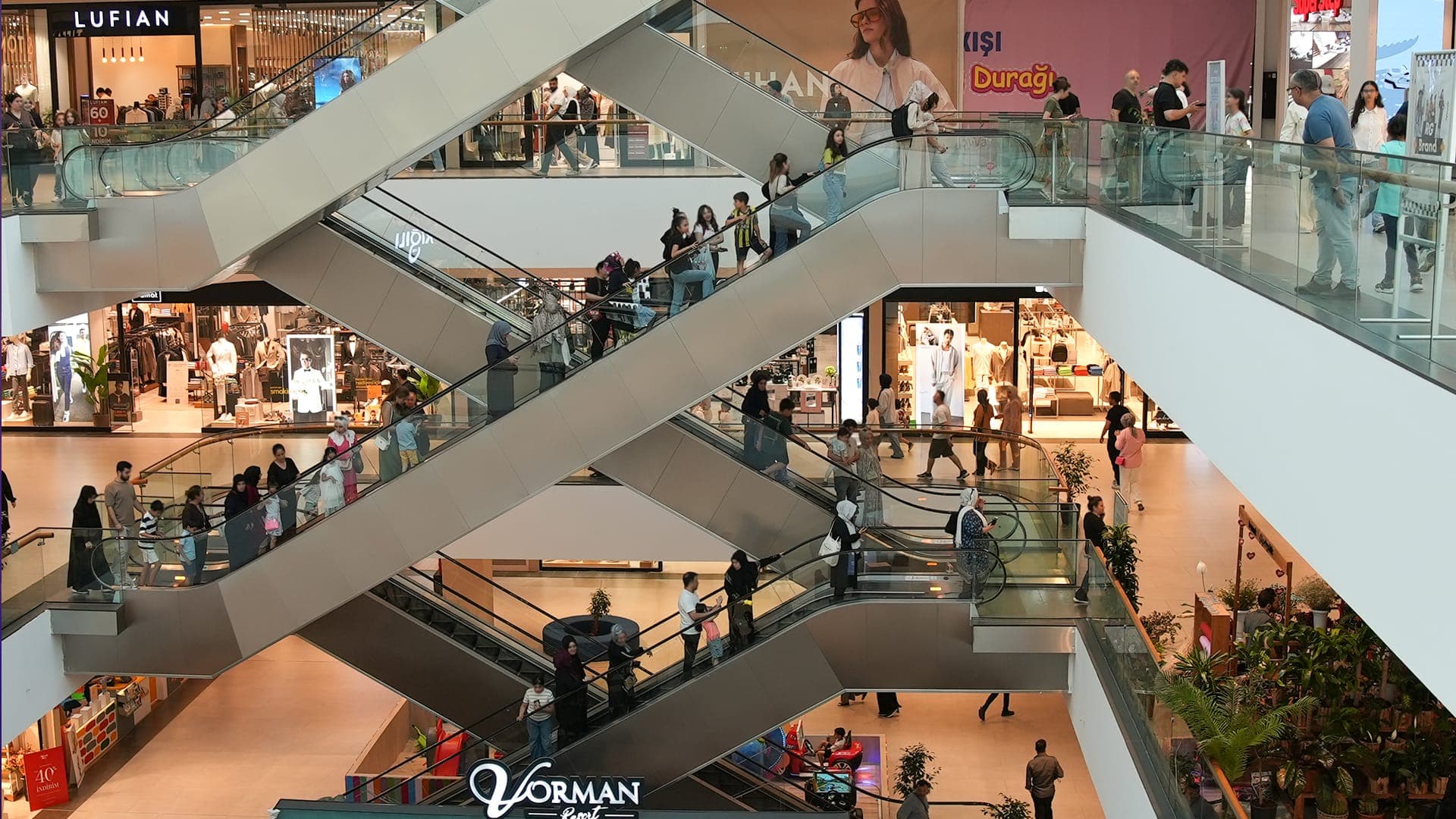 V Metroway galerisi; üst kattan görünen kesişen yürüyen merdivenler ve mağaza katları